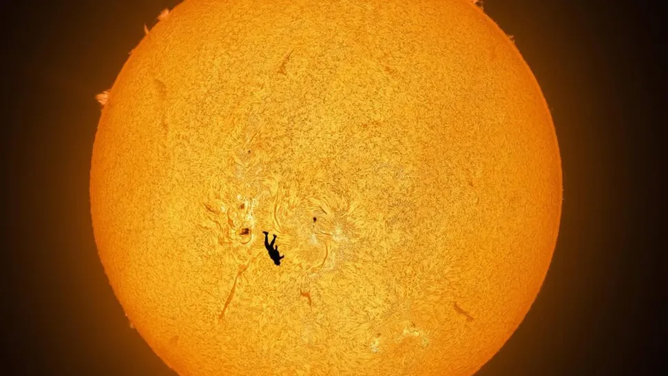 Silhouette d'un parachutiste devant le soleil